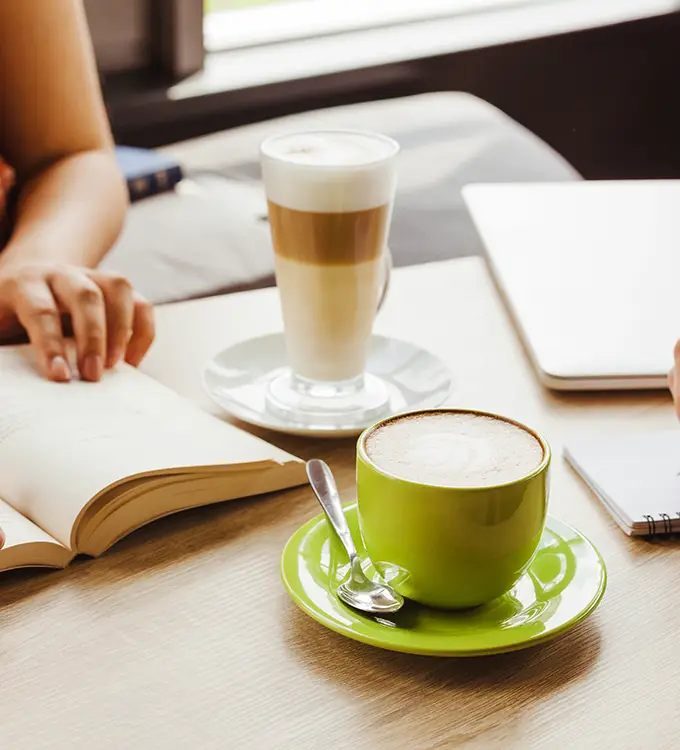 Personnes lisant autour d'un livre et d'un café